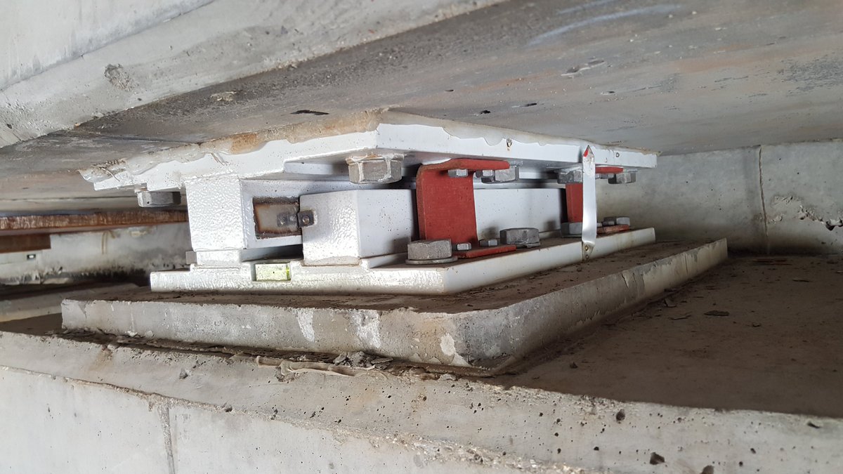 Next, the sliding bearing. This has two plates that slide past each other, allowing movement in one axis only. This is generally used along the centrelines for equal movement, and keeps the bridge centred as it moves. There is a ruler with centreline to measure movement.