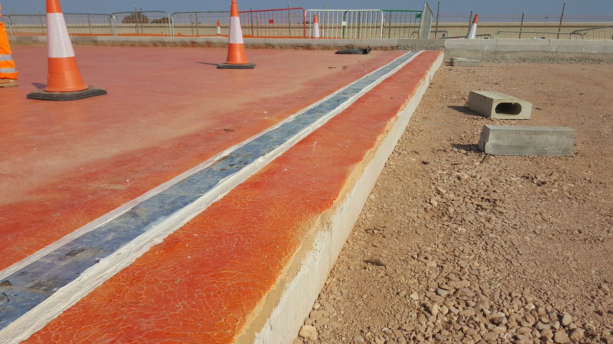 The simplest type is a buried joint. A metal or rubber plate bridges the gap from abutment to deck, the asphalt surfacing laid, and then a cut is made in the road. The cut is sealed with bitumen, and this is flexible enough. The metal plate is shown in these photos.