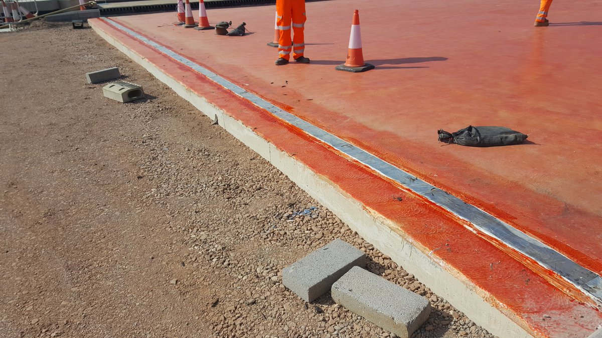 The simplest type is a buried joint. A metal or rubber plate bridges the gap from abutment to deck, the asphalt surfacing laid, and then a cut is made in the road. The cut is sealed with bitumen, and this is flexible enough. The metal plate is shown in these photos.