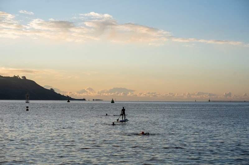 PhotoJ_USW's tweet photo. Plymouth, UK. New Years Day 2021. Open water swimming and paddle boarding by current student @ButtersKira #photojstudent #photojournalism @UniSouthWales https://t.co/F5xZVh87mo