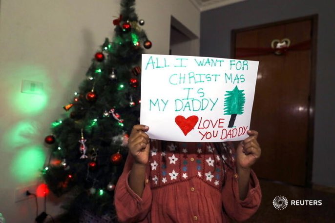 ReutersPR's tweet photo. The daughter of Reuters cameraman Kumerra Gemechu poses with a note she prepared for her arrested father next to a Christmas tree in Addis Ababa, Ethiopia December 30, 2020. REUTERS https://t.co/qlWyQPOqJV