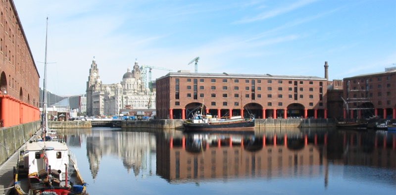 Au 19è siècle, le développement économique de Liverpool est lancé avec la construction de son port, le plus influent d’Angleterre. Cela permet l'investissement de capitaux étrangers, et le contrôle de nombreux flux, notamment ceux des marchandises à destination de Manchester