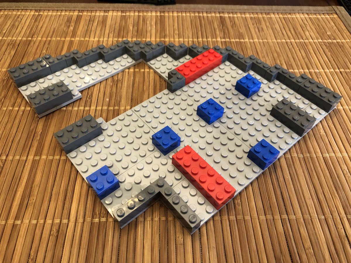 This section has a hole in the all black floor with light grey trim, a white border, and directional markings on top.  #LEGO  