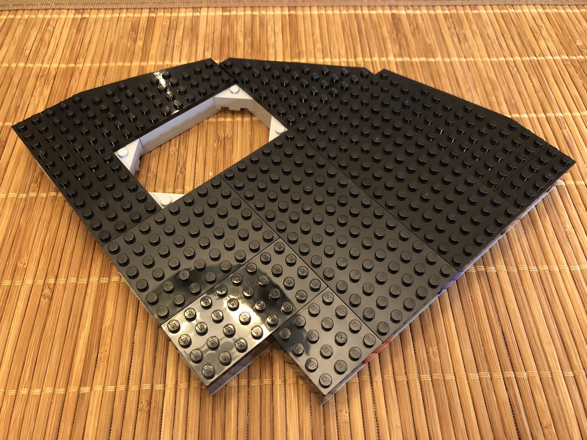 This section has a hole in the all black floor with light grey trim, a white border, and directional markings on top.  #LEGO  