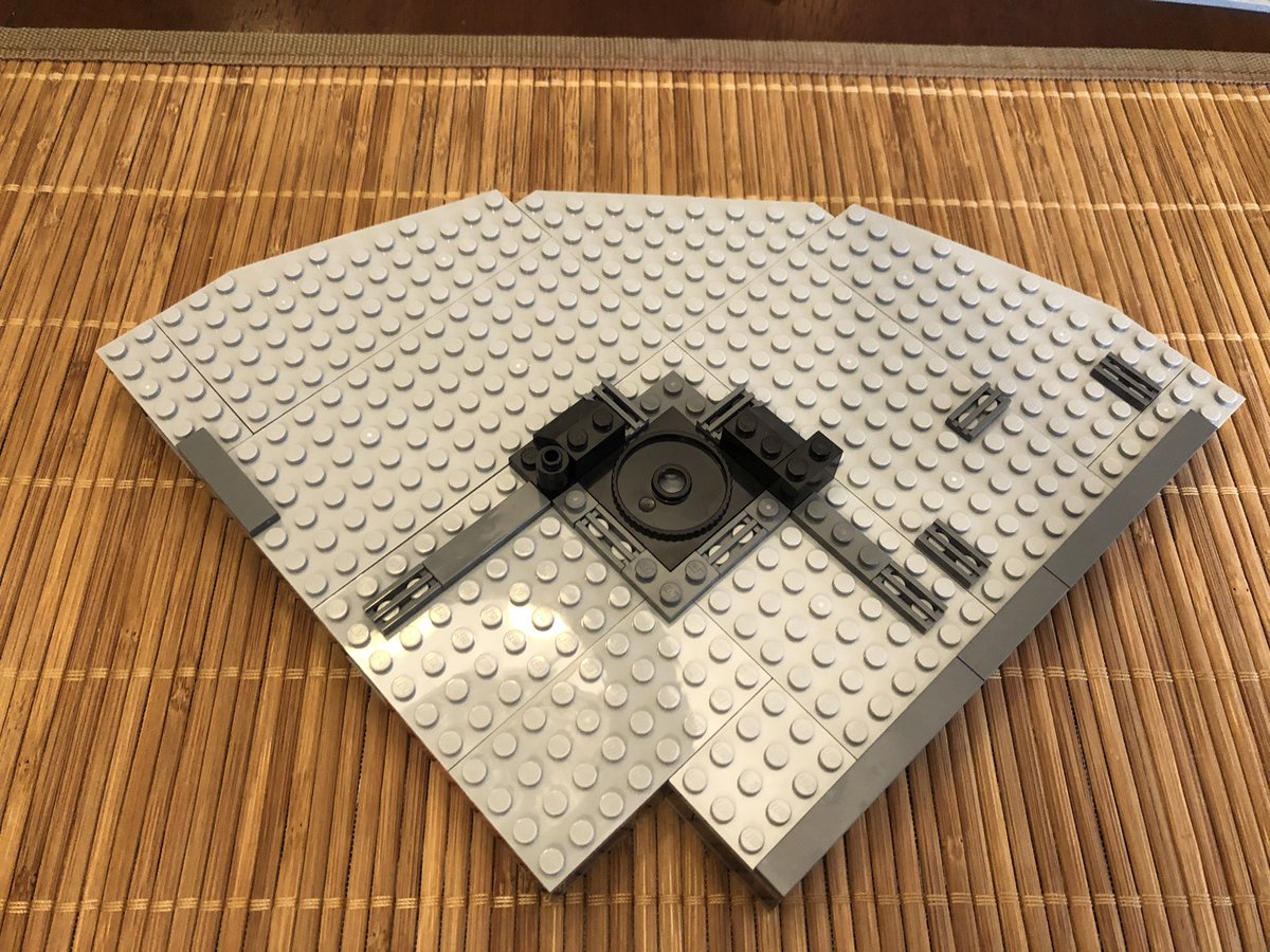 This quadrant goes above the cargo bay. The next section has a cutout on the bottom side, but has a smooth surface. A rotational piece goes in the center, with some decoration around it.  #LEGO  