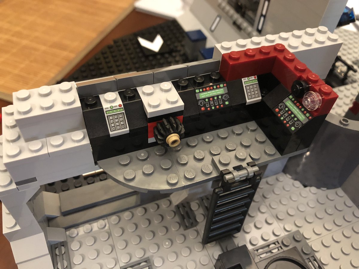 To place the mechanism. We need a second story, with a ladder to get up, and a set of consoles with the gear in the middle. Turn it to control the door below.  #LEGO  