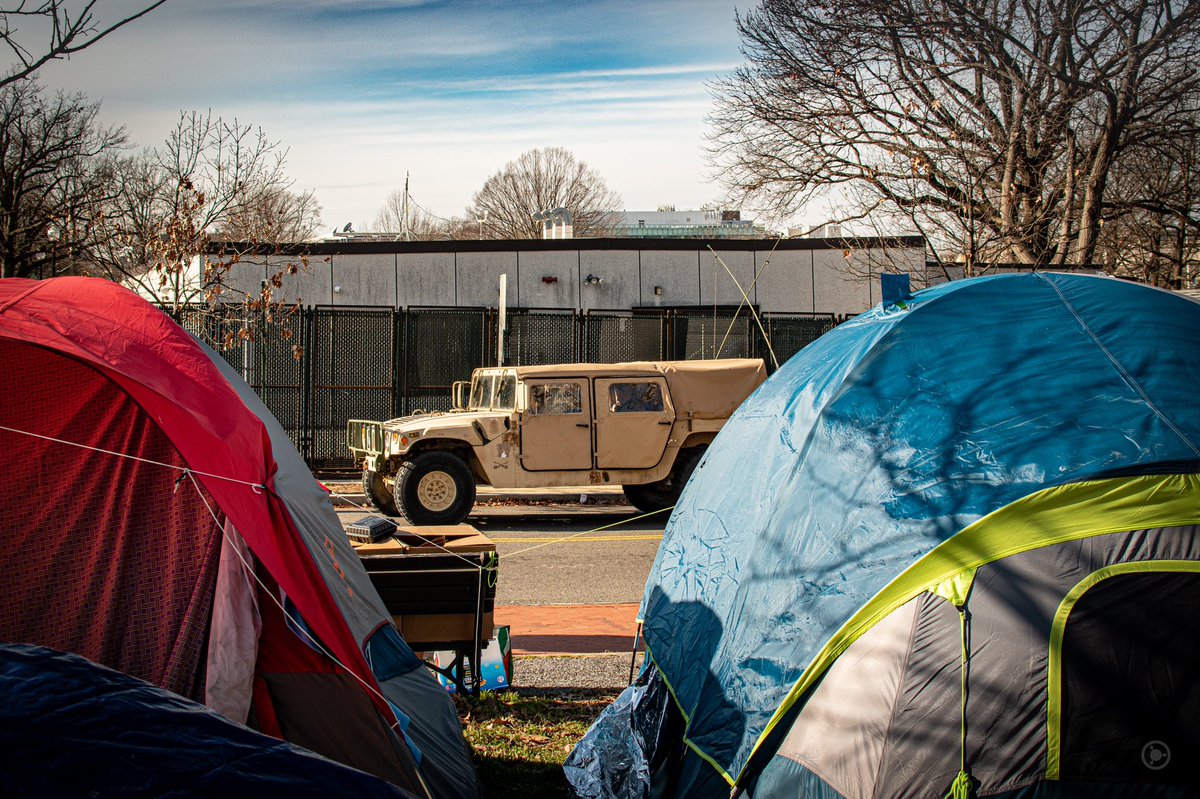 Humvees rumbled by encampments where housing challenged people had gathered for protection.I wondered what the cost of all this extra security was.I wondered what the budget for housing people in DC is. #DCLockdown  #BenjaPhoto