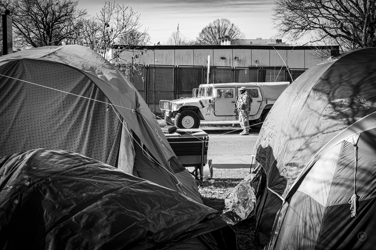 Humvees rumbled by encampments where housing challenged people had gathered for protection.I wondered what the cost of all this extra security was.I wondered what the budget for housing people in DC is. #DCLockdown  #BenjaPhoto