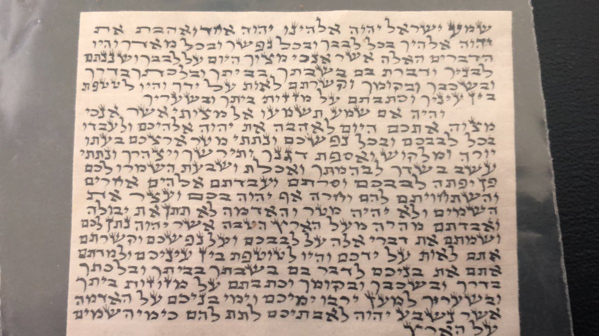 Here is an example of what we find inside.Written on parchment, using a quill, these words are a •creed• for Jews. They detail the unity of God, love of God, education, reward and punishment, etc.It’s in all doors except toilets  and bathrooms (nudity).2/4