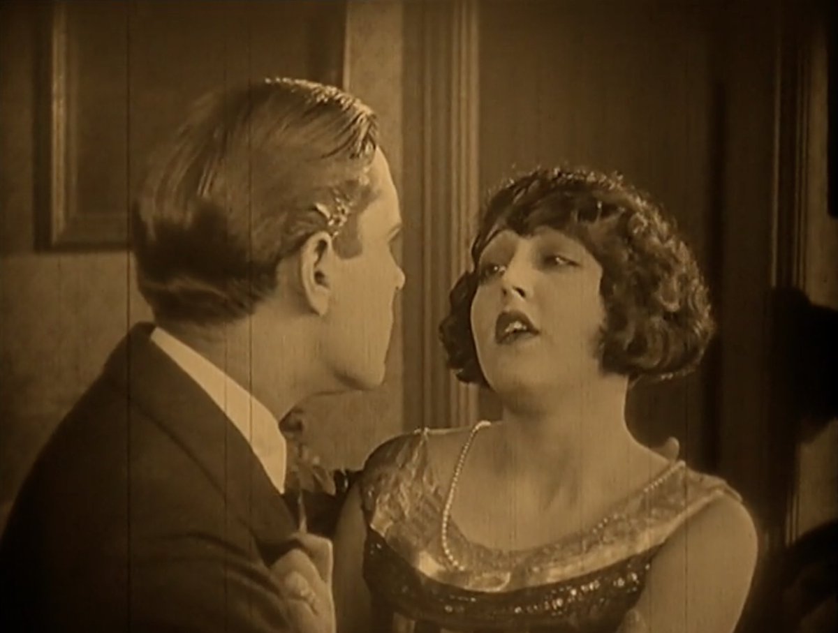 Watching a silent movie and boy does Gladys have high standards