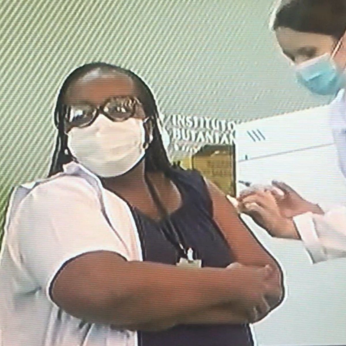 inst_marielle's tweet photo. Olhadinha pro lado pra não ver a agulha, mas o sorriso de quem tem a coragem de lutar na linha de frente contra a Covid! 

Emocionante assistir Mônica Calazans, mulher negra, que se formou como enfermeira aos 47 anos e encarou as UTIs na pandemia, tomar a 1ª vacina! #vemvacina https://t.co/dfUlE9KS6u