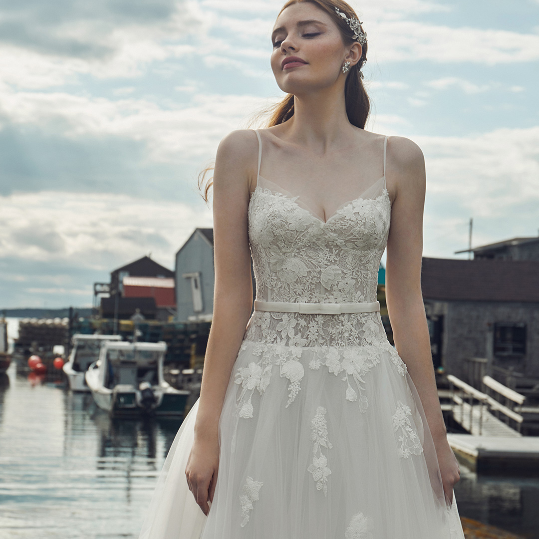 River LA20133 was designed to exude sensuality. 😍 This enchanting #weddingdress features a drop waist silhouette to accentuate and cinch, giving you that desired hourglass figure. Cheeky spaghetti straps and cascading floral appliqués complete this bombshell #bridallook!