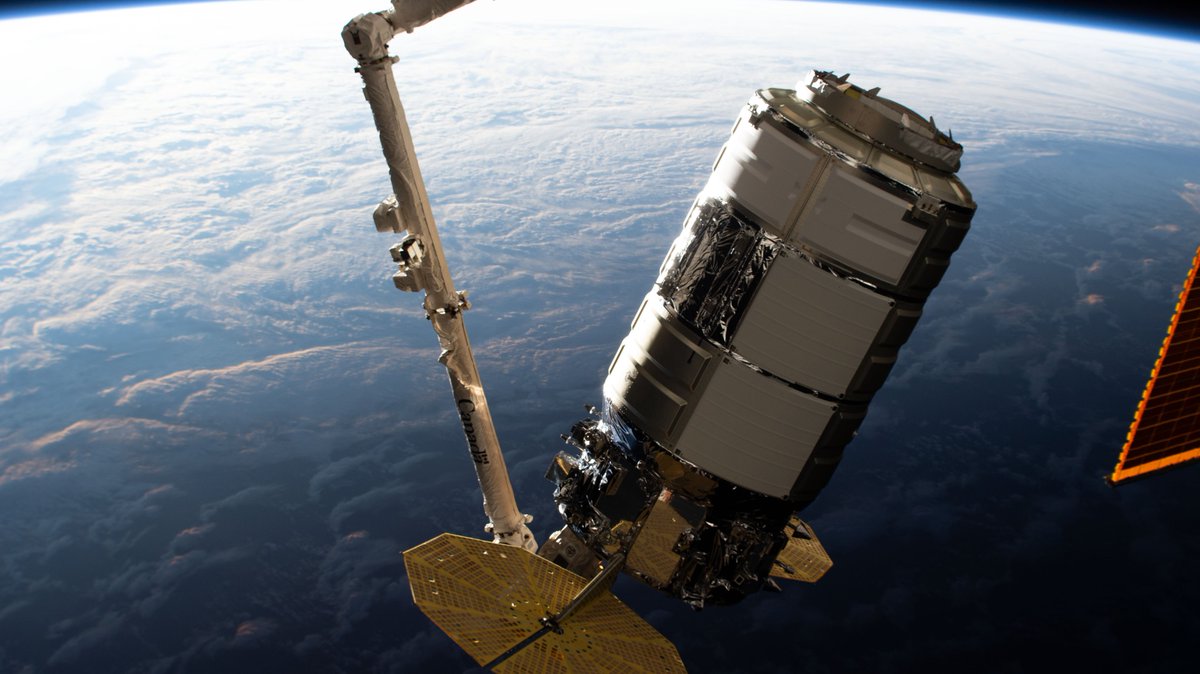 The Northrop Grumman Cygnus space freighter is pictured in the grips of the Canadarm2 robotic arm.
