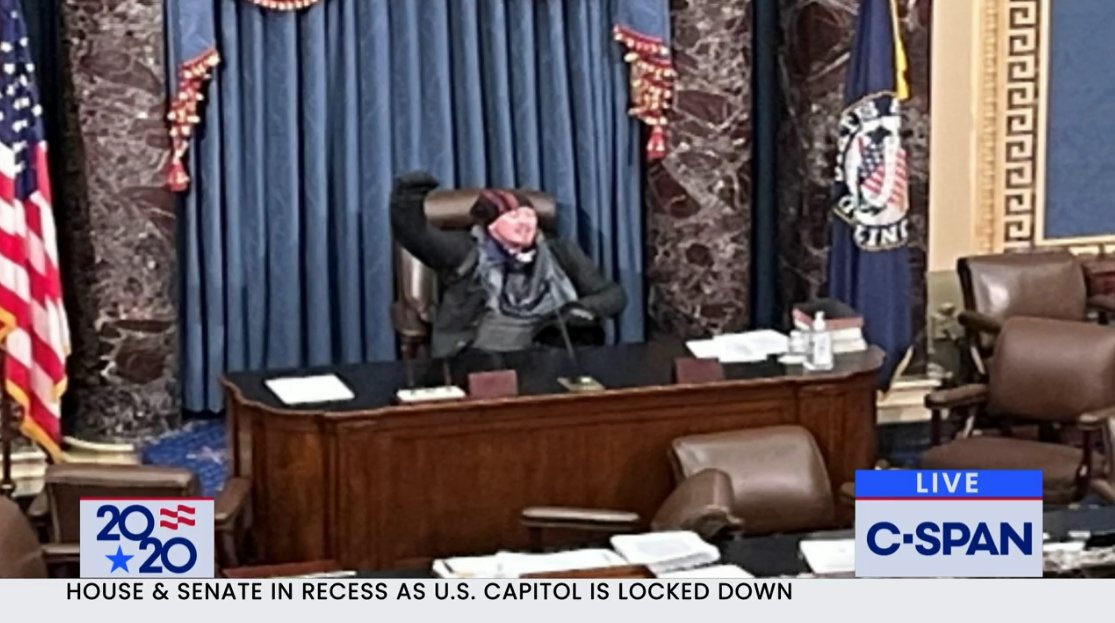 almuariza's tweet photo. Un manifestante trumpista en la silla del presidente del Senado de los Estados Unidos. La imagen de la decadencia en la supuesta “primera democracia del mundo”. #Capitolio https://t.co/cf523TNFrg