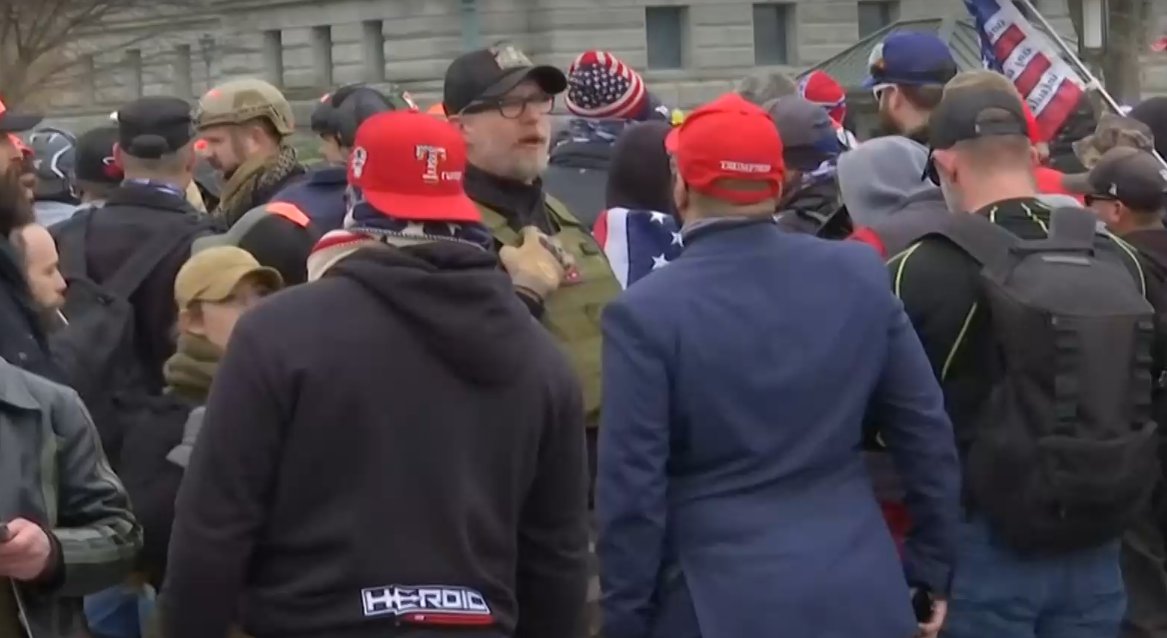 3/ Proud Boys founder Gavin McInnes is in the crowd, wearing a plate carrier and black baseball hat and generally looking stupid.