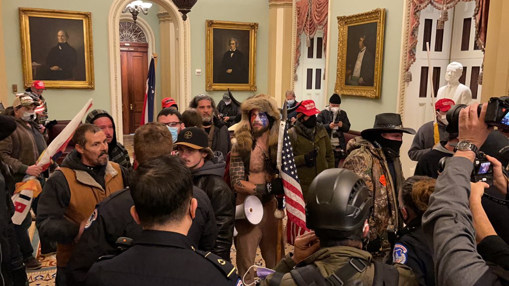 Police officers are holding them steps away from the Senate chamber, which is locked. Senators are inside. I see a few confederate flags.