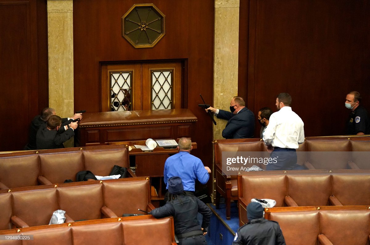 Law enforcement officers point their guns at a door that was vandalized in the House Chamber during a joint session of #Congress after Trump supporters breached the U.S. Capitol in Washington, DC #USCapitol #CapitolBuilding 📷: <a href="/drewangerer/">Drew Angerer</a>