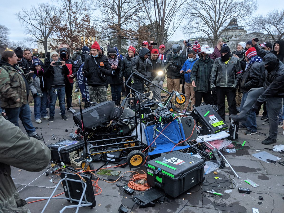 A bunch of Associated Press equipment had to be abandoned and a crowd is trashing it. 'We are the news now!' a man yells. Looks like they're going to try to light it on fire.