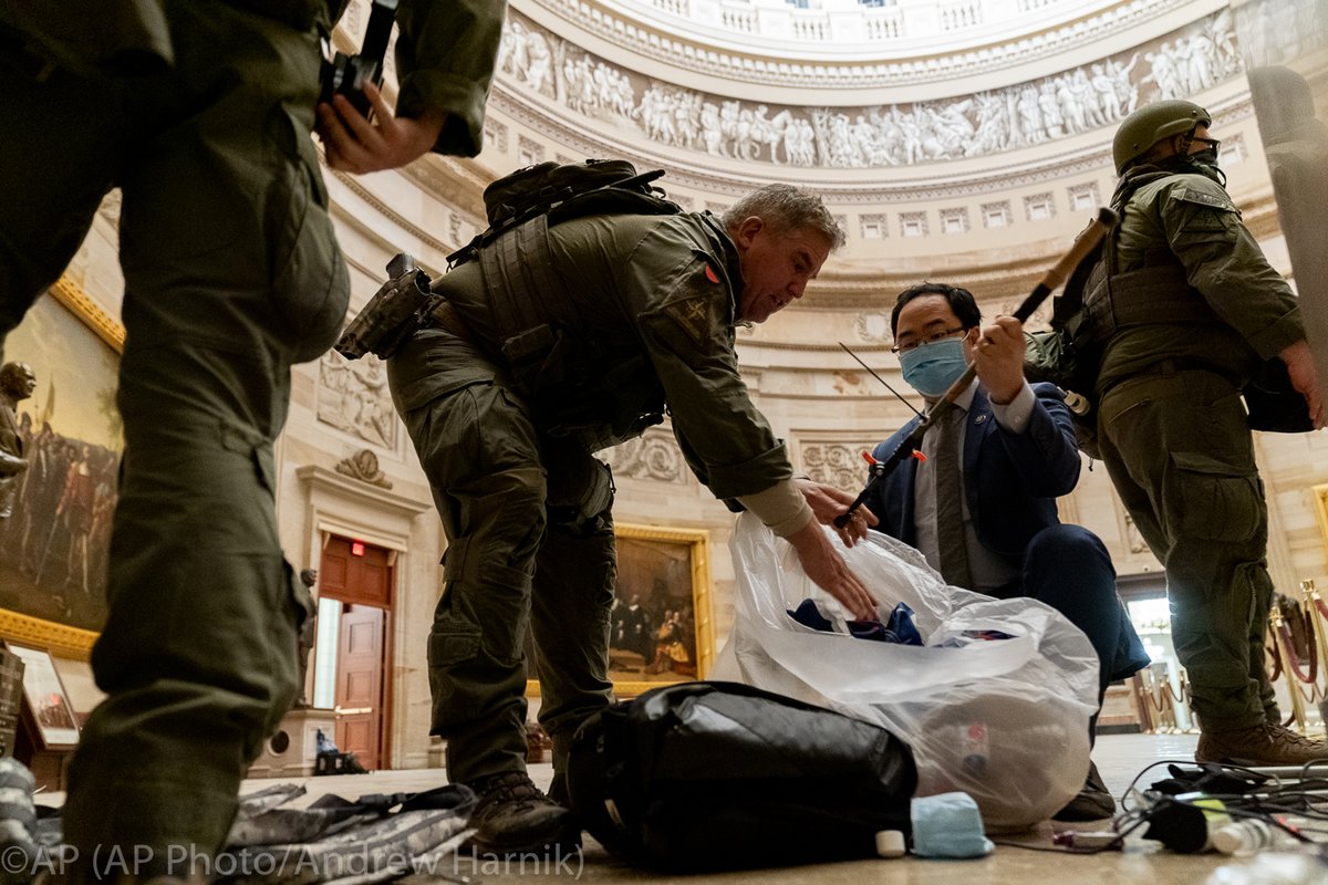 Rep. Andy Kim, D-N.J., helps ATF police officers clean up debris and personal belongings strewn across the floor of the Rotunda in the early morning hours of Thursday, Jan. 7, 2021, after protesters stormed the Capitol in Washington, on Wednesday. (AP Photo/Andrew Harnik) @ap