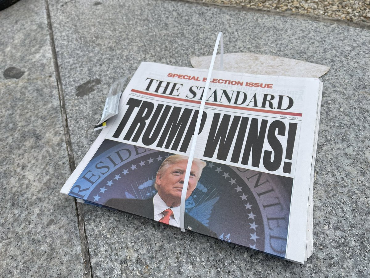 2:02pm: I passed by these on Constitution Ave. Someone went to the trouble of printing actual fake news and left bundles on the street free for people to read