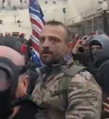 JakeGodin's tweet image. Images of the guy who was being super aggressive toward the journalist (there's something written on his hat "---ztown"?) and the one who assisted in pushing him over the stone railing (wearing camo with a backpack).