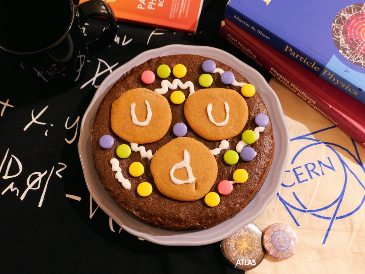 PhysicsCakes's tweet photo. #GreatPhysicsBakeOff

@1crebeca and @coniavitis baked a proton on a kladdkaka, a Swedish mud cake. 

“The uud quarks are made of gingerbread, the sea quarks are @smartiesUKI, and our gluons are made of frosting.”

Imagine trying to collide protons that big inside the #LHC @CERN! https://t.co/CodSkLUruv