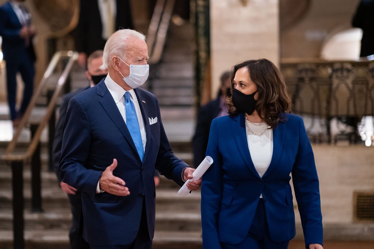 Joe and Kamala speaking to each other, both wearing masks