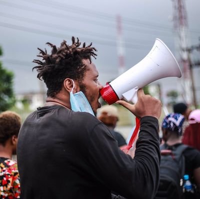 omolalomi's tweet photo. Picture A is Eromz that went about his #EndSARS protest peacefully.

Picture B is a hoodlum, used by some elements in the government to violently attack and disrupt peaceful protests.

Eromz is being charged to court while the other guy roams free.

  #FreeEromz https://t.co/5ehweqDial