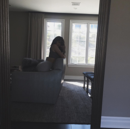 kylie jenner wrestles the backseat of a couch in an absolute Hail Mary attempt at sitting 