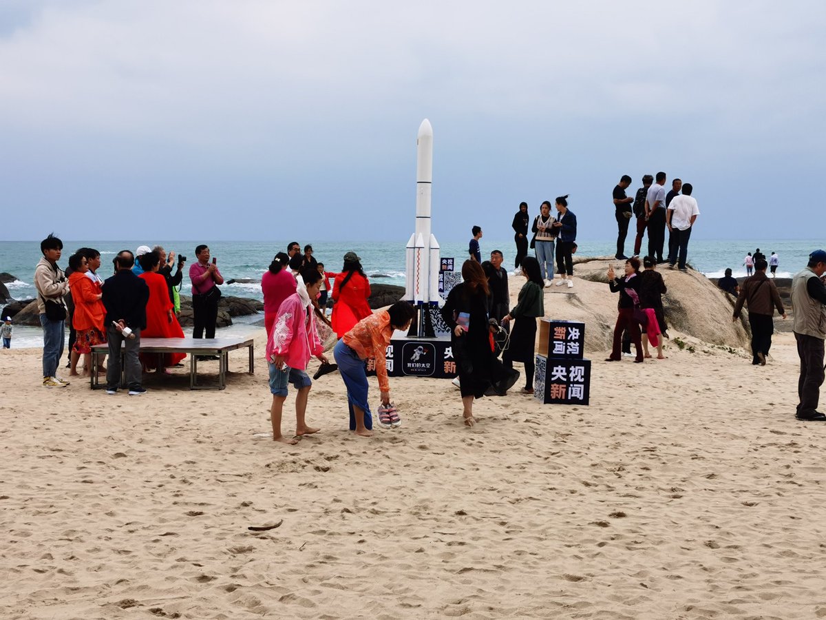 随着时间的推移，海滩上的人越来越多，逐渐变得拥挤。图4是从望远镜里看到的长征五号火箭。