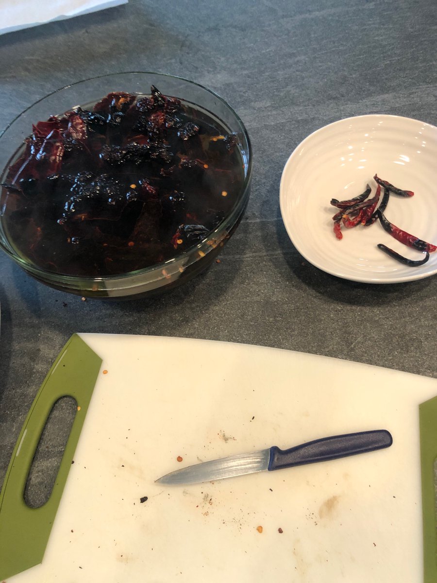 Separate the chilis de arbol from the others, break them apart and deseed them. Then soak them in hot water for 45 min. Cover each bowl with a plate.