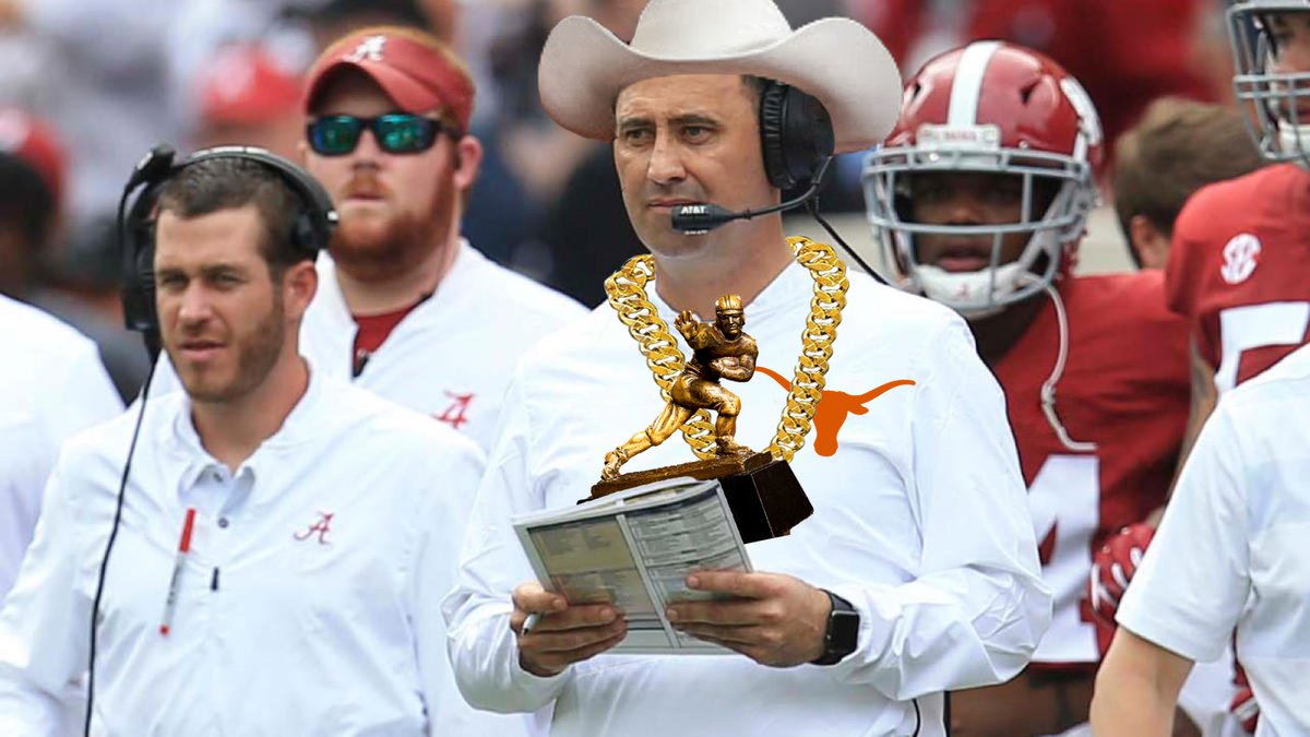 Coach Steve Sarkisian on the Alabama sideline wearing Davonta Smith's Heisman Trophy over a Texas Longhorns polo