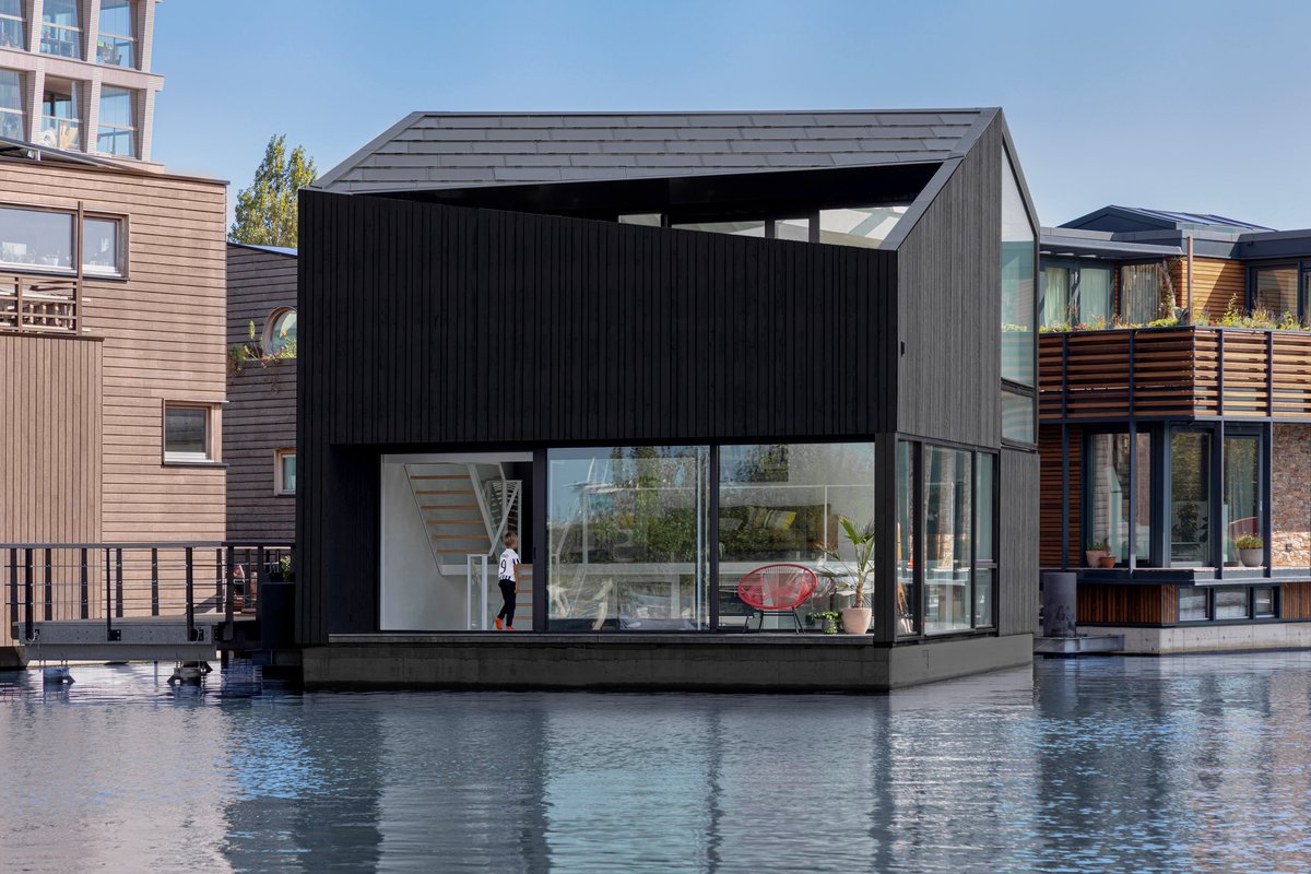 For a floating village in Amsterdam, design firm i29 has created a three-story home that features angled openings and dark timber cladding. The interior is amazing; see photos here: dezeen.com/2021/01/11/i29…  #architecture