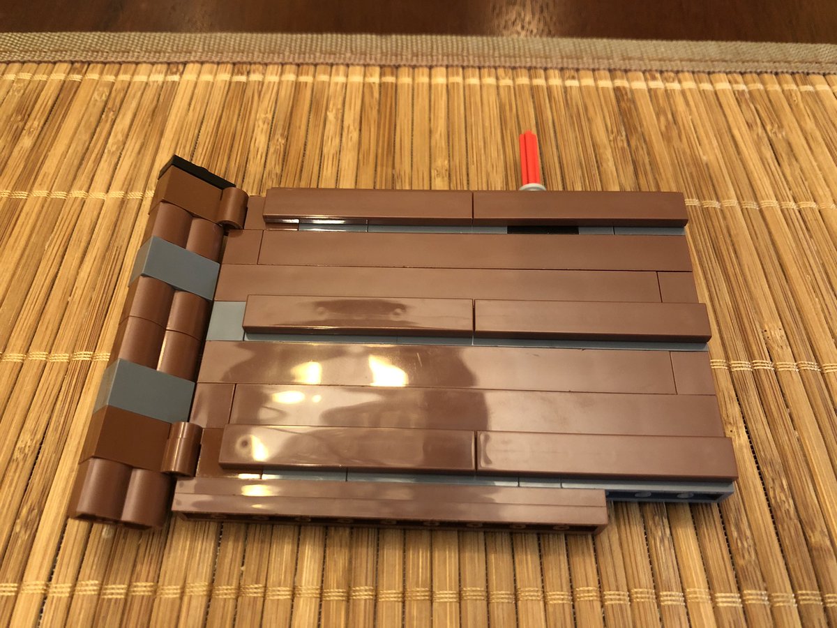 Some flat plates go on the pegs, giving the wall a polished look. Build another wall, hinged the other way, and attach them to either side of the door - figure out what it is yet? Then a few more layers go above the door.  #LEGO  