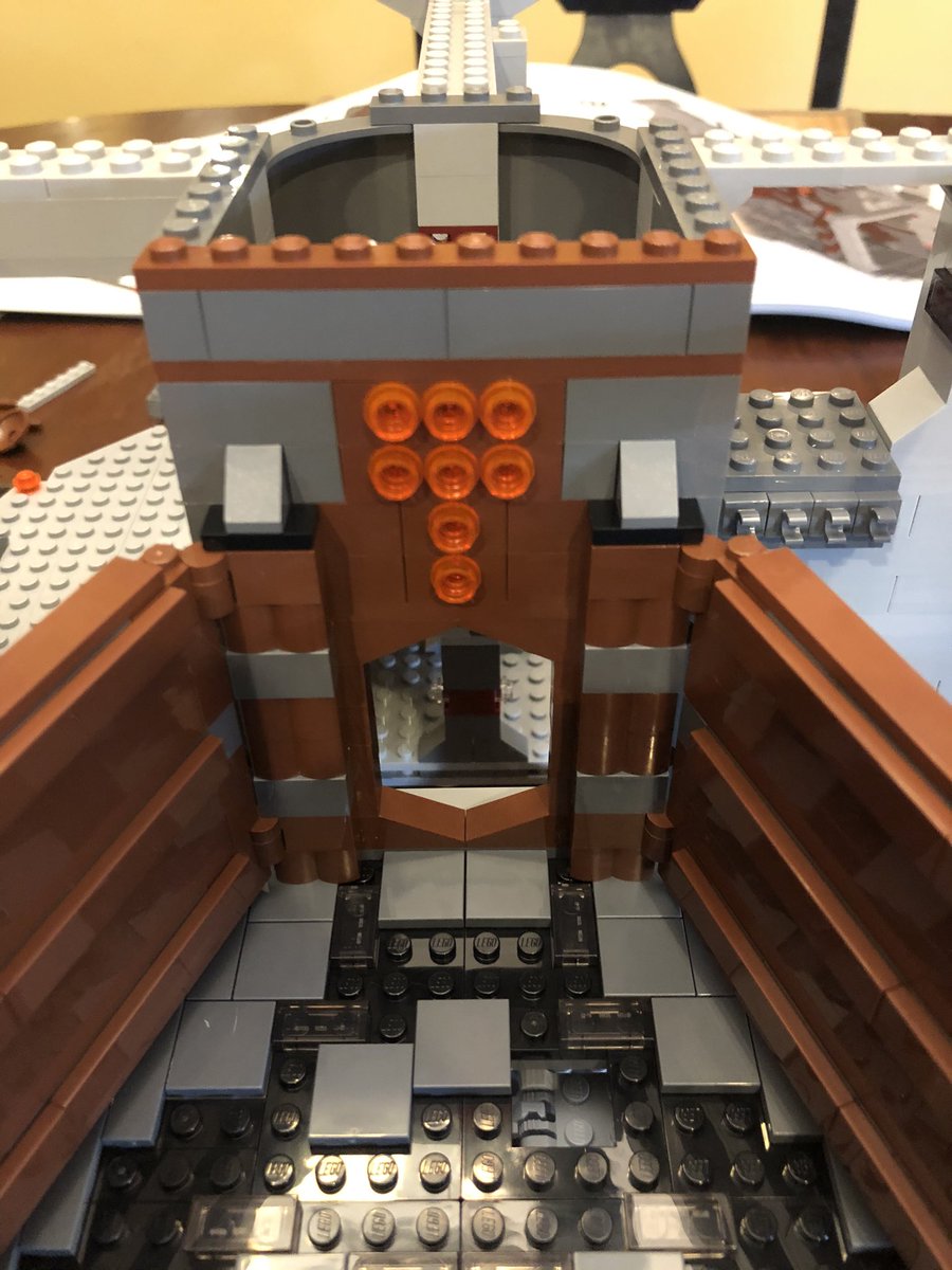 Some flat plates go on the pegs, giving the wall a polished look. Build another wall, hinged the other way, and attach them to either side of the door - figure out what it is yet? Then a few more layers go above the door.  #LEGO  