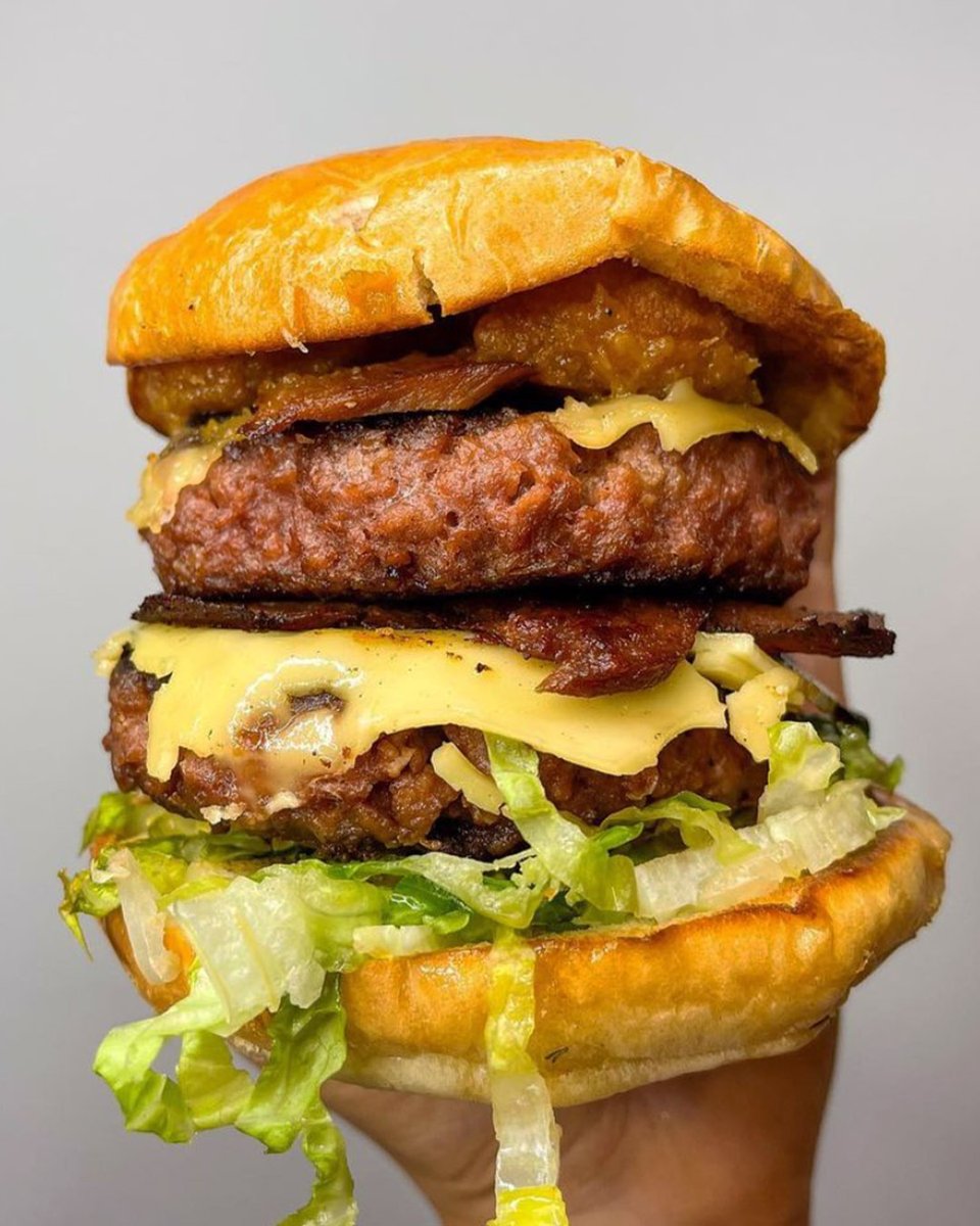 Great shot here of a doubled up vegan Tribute to Jamaica, made with THIS Plant based patty &amp; bacon, vegan smoked gouda, <a href="/DeesTable/">Dee's Table</a> apricot &amp; scotch bonnet ketchup, plantain fritters, Jamaican curry 'mayo' and lettuce.

ONLY HERE FOR JAN.

📸 - @aveganandhercat - IG
