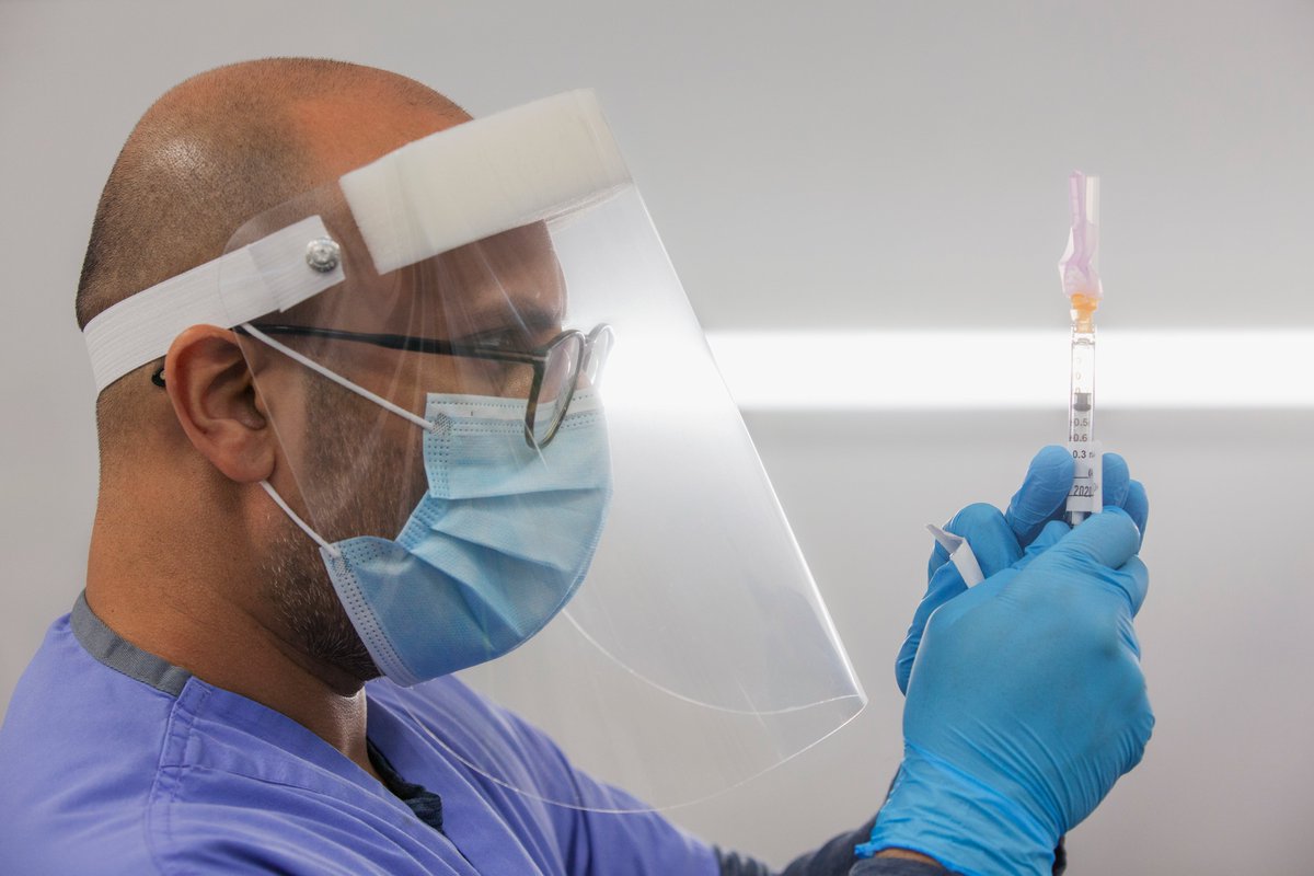A THP doctor prepares a syringe containing the COVID-19 vaccine.