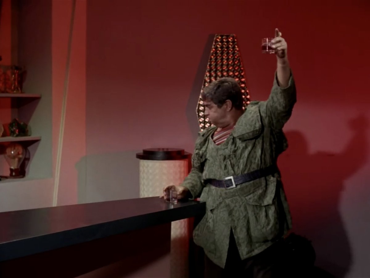 I remembered that in a big fight scene on a space station in that episode, he does the same thing, gingerly exiting with his drink held high, and they make a meal out of the joke. With multiple shots of him doing that. (5/9)