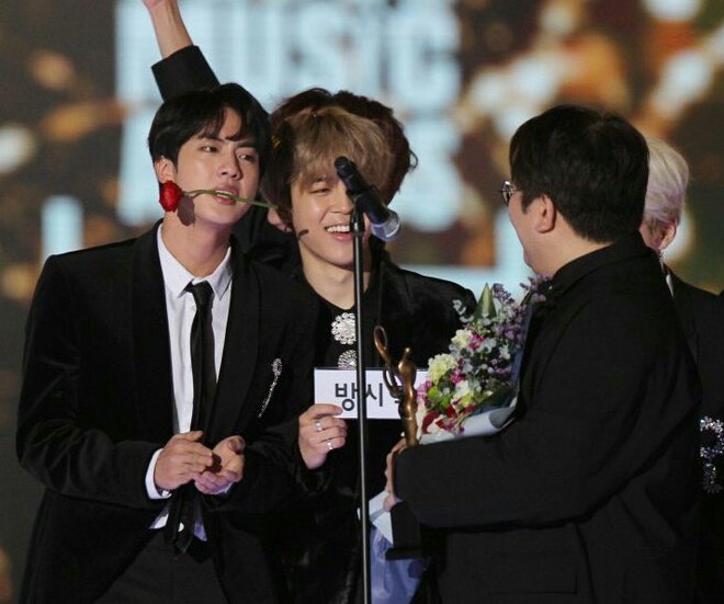 When bang pd won producer of the year and bangtan went on stage with him. Seokjin bit the rose and bang pd also put it in his mouth making tannies laugh + this seokjin tweet too