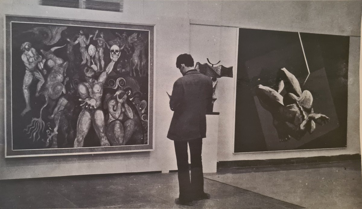 From the First Biennale of Arab Art, which took place in 1974 in Baghdad.This photo was taken in the Iraqi section, with a painting by Jawdet Haseeb on the right and a painting by Tariq Madhloum on the left.
