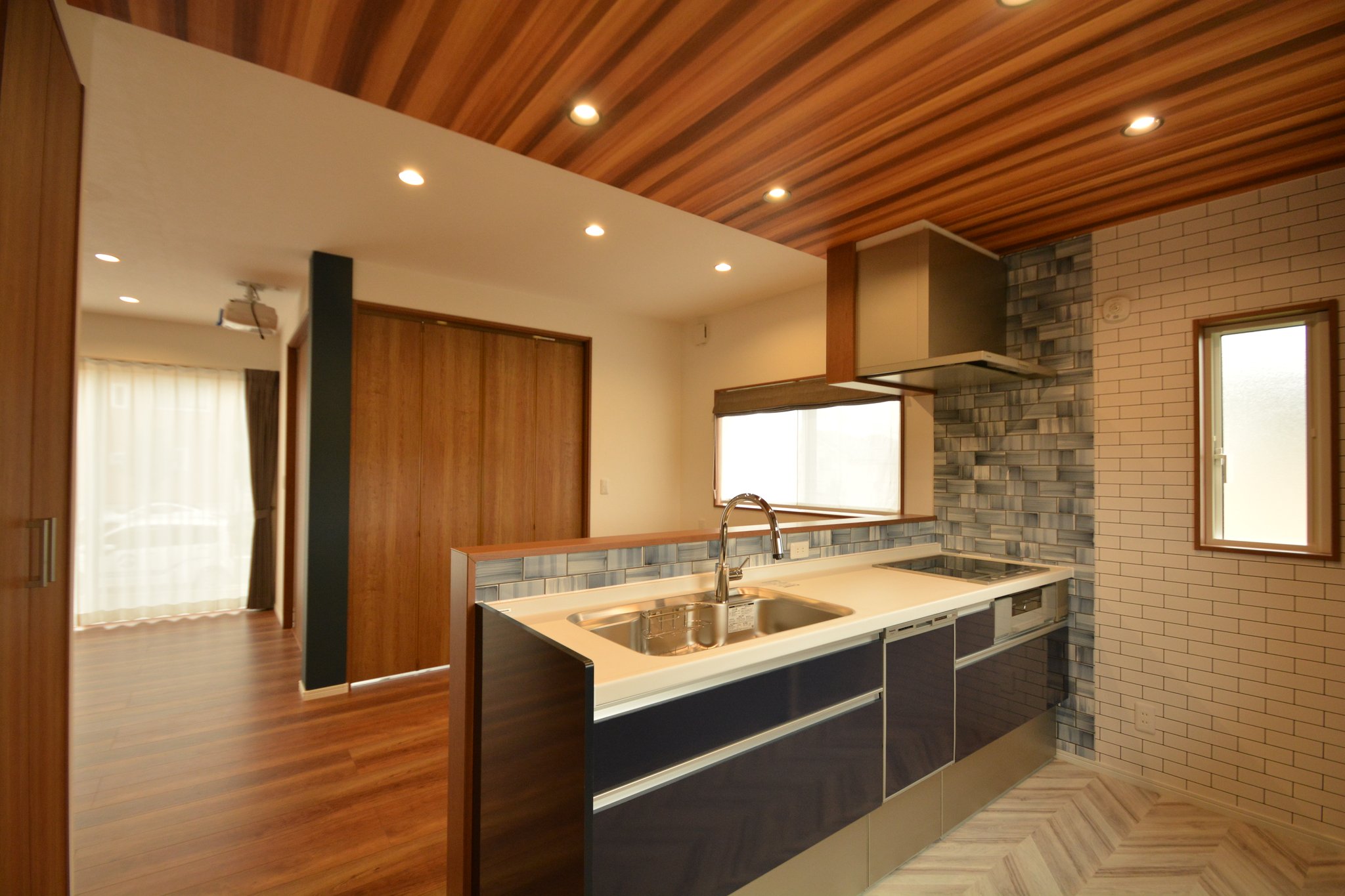 株式会社 アイアールホーム 在 Twitter 上 木目 ネイビーのキッチン 少し天井を下げてクロスを木目に 違う空間のように感じられます コンロ側の壁は油が飛んでもサッとふけるタイルを採用 キッチンの色と合わせているのも素敵です お家紹介 施工事例