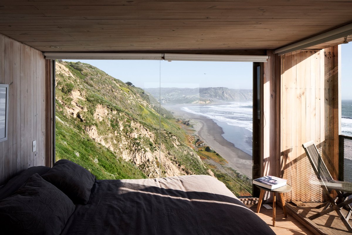 dezeen's tweet photo. These two minimalist cabins are set high on a hill overlooking the Pacific Ocean in Chile: https://t.co/E9mI3C3Dg1 https://t.co/i8iFZynXs4