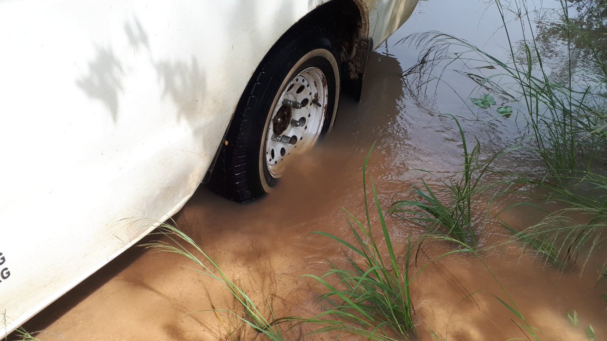 Enter return trip. We get stuck in a puddle. No help in sight as there are no homesteads nearby. We clear sand in front of the tyres and place pebbles and small boulders but car just won't move. It rains and car tyres get further partially submerged in water. Stress.