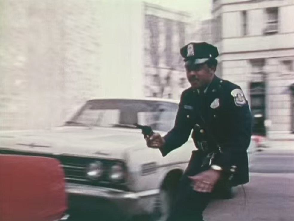 The film begins with a vignette of a lone police patrolman chasing an armed liquor store robber. He makes good use of cover as he advances down an alley.3/