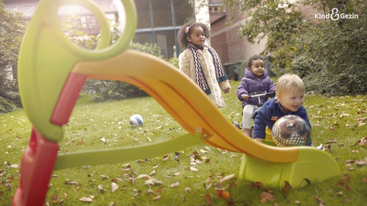 3 kindjes spelen in de tuin aan de glijbaan