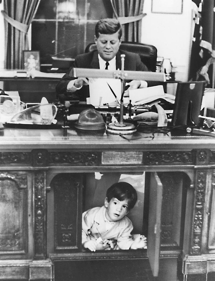 FDR had ordered a door / the presidential seal to hide his leg braces, but he died before it was installed. Jackie Kennedy rediscovered the Resolute desk in 1961. A Scotch-taped cover & film equipment obscured it in the Broadcast Room. JFK, Jr. shown playing at his father's feet.