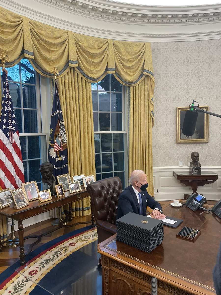 President Biden begins signing a tall stack of executive orders during his first Oval Office appearance for press.