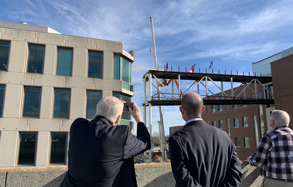 MDHParrish's tweet photo. Dean John Sutherland of College of Science and Mathematics @AUG_University takes photo of steel beam going up on pedestrian bridge at "Raise the Beam" event Wednesday #BeyondBoundaries #BeBoundless #JagNation @AugCSM @MCG_AUG  @PresKeel @aug_provost @russellkeen76 @SuzanneTatum https://t.co/hQ8yCeGiZR