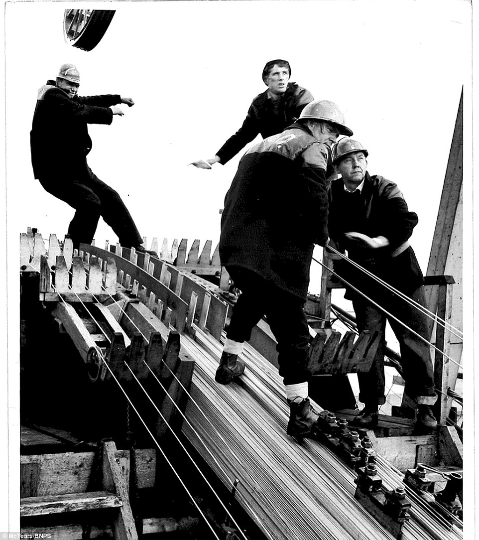 That's not all they braved.These men are helping to fix the steel suspension cables into position, 500ft above the Firth of Forth.