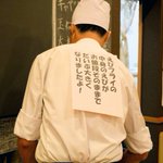 スペースの有効活用？とんかつ屋さんの店長。何故か背中に張り紙をしてお仕事中。